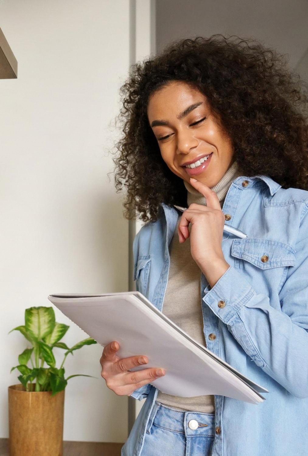 Smiling employee in a denim shirt reviewing an assessment booklet in a UAE office